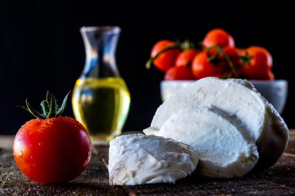 Tomatoes, olive oil and mozarella on a wooden table